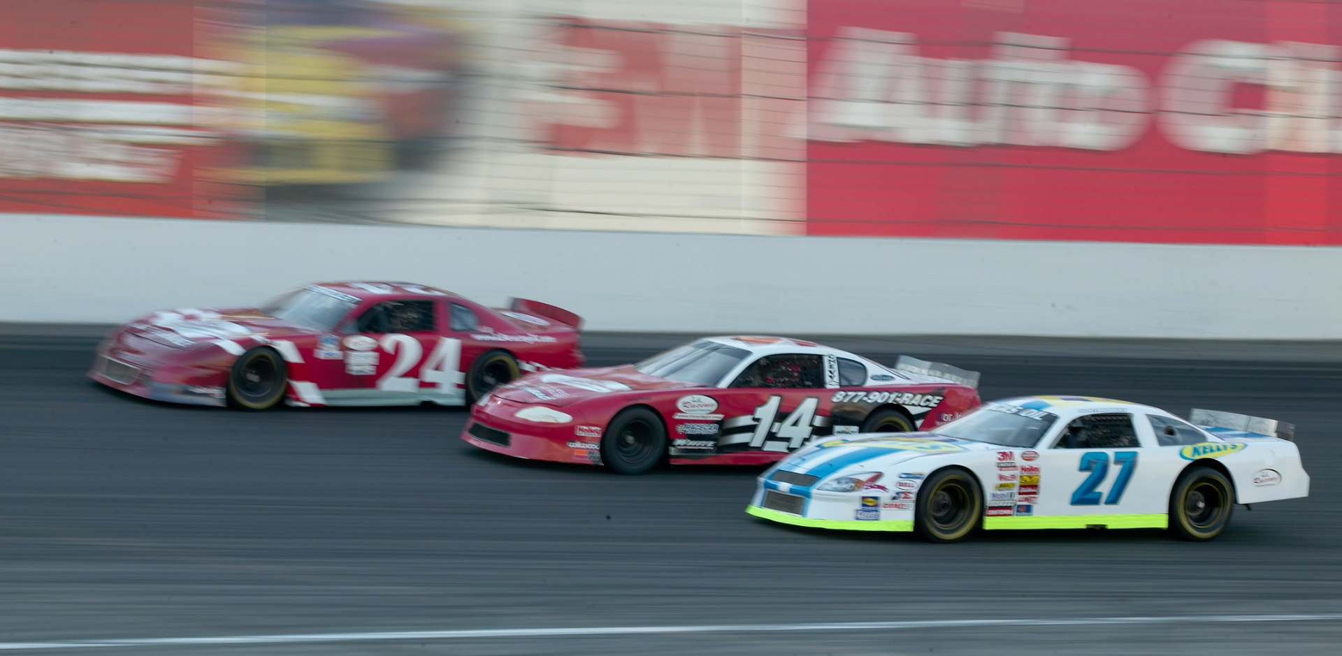 Kelly's #27 car racing on track with competitors